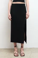 Falda midi negra de punto con abertura lateral.