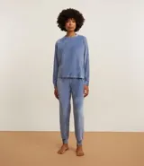 Conjunto de pijama largo confeccionado en plush, compuesto por una blusa de manga larga con cuello redondo y un pantalón con cintura elástica y puños ajustados en los tobillos.