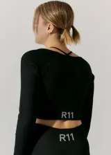 Top de manga larga confeccionado en tejido seamless, con diseño de cuello cuadrado y tirantes finos tipo espagueti. Presenta una textura acanalada y un corte cropped que se ajusta al cuerpo.