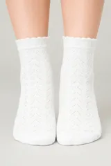Medias blancas de algodón con diseño de punto calado y borde superior con volados. Presentan un tejido transpirable con detalles acanalados y textura de trenzas, ofreciendo un ajuste cómodo y un estilo delicado.