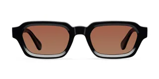 Lentes de sol con montura cuadrada de color negro y cristales polarizados en tono marrón. Presentan un diseño retro con parte superior plana y patillas con detalle sobresaliente.