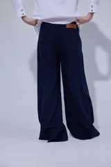 Pantalón de tiro medio y piernas anchas, confeccionado en mezcla de lino y algodón, con bolsillos delanteros y traseros con detalles de costuras pespunteadas a contratono.