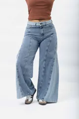 Jean wide leg azul claro con paneles de mezclilla de diferentes tonos y costuras diagonales.