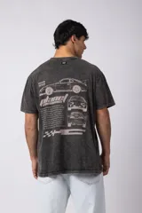 Remera de algodón peinado con efecto desgastado (snow wash), color gris oscuro. Presenta un estampado frontal con texto y un patrón de cuadros de carreras.