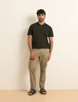 Pantalón cargo color verde militar, de corte recto, con bolsillos laterales con fuelle, bolsillos delanteros inclinados y bolsillos traseros.