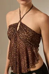 Top de cuello halter con diseño fruncido y caída holgada, confeccionado en tela con estampado de puntos.