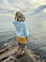 Poncho de toalla con capucha, diseño color block en celeste, amarillo y gris. Capucha con estampado floral.
