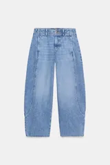 Jeans de tiro alto con corte barrel, pernera holgada que se estrecha hacia el tobillo y bajo deshilachado. Presenta costuras verticales decorativas en el frente y cierre frontal con cremallera y botón.