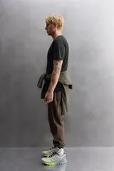 Camiseta de entrenamiento de ajuste regular, color verde oliva, confeccionada en tejido técnico ligero y elástico con estructura. Presenta cuello redondo, manga corta y costuras planas.