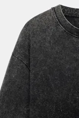 Camiseta de algodón con efecto lavado, cuello redondo y manga corta. Presenta un acabado con sutiles brillos integrados en el tejido y un corte regular.