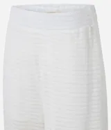 Pantalón estilo aladín blanco, de tejido piqué texturizado, con cintura elástica y puños ajustados en los tobillos.