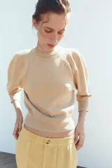 Jersey de punto color amarillo claro, con cuello redondo y mangas abullonadas.