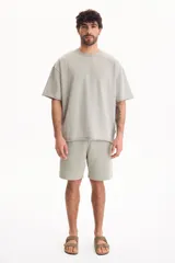 Remera oversize gris oscuro con efecto lavado, cuello redondo y mangas cortas amplias.