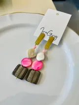 Aros colgantes con base dorada y dijes de nácar, vidrio y cuentas de colores rosa, blanco, beige y marrón.