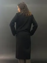 Tapado largo de paño de lana color negro con estampado abstracto brillante en el frente. Tiene cuello con solapas, bolsillos laterales y terminación al tallo vivo.