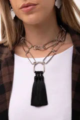 Collar de eslabones rectangulares plateados, con diseño versátil que permite usarlo largo o doble. Incluye un dije central en forma de herradura con tres borlas negras colgantes.