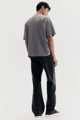 Remera gris de algodón de peso medio, corte oversized, con cuello redondo ribeteado, hombros caídos y bajo recto.