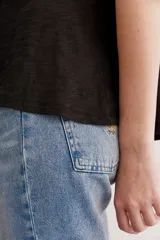 Remera de algodón peruano color naranja, de calce holgado, con largo irregular y ruedo redondeado.