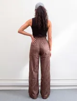 Pantalón wide leg de tiro alto con estampado animal print en tonos marrones. Presenta pretina ancha, cierre frontal con broche y bolsillos laterales aplicados.