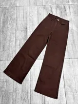 Pantalon jean de corte recto y tiro alto, color marrón chocolate. Presenta cierre frontal con botón metálico y bolsillos laterales.
