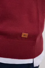 Suéter de punto color azul marino con cuello en V y manga larga. Se lleva sobre una remera blanca con cuello en V.