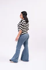Pantalón jean estilo oxford de tiro alto, color azul intermedio, con calce ajustado en cadera y muslos, y bota ancha acampanada.