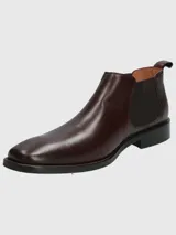 Bota tipo Chelsea de cuero en color bordó, con paneles laterales elásticos y suela de goma negra.