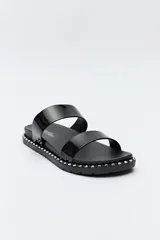 Sandalias planas plateadas con dos tiras anchas y suela negra con detalles metálicos.