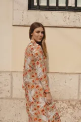 Túnica beige con estampado de lobos blancos y besos rojos, de lino y algodón, con cuello solapa y largo por debajo de la rodilla.