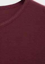 Camiseta de cuello redondo y manga corta con dobladillo, confeccionada en algodón, con diseño recto y ajuste al cuerpo.