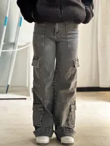 Jean cargo de mujer color gris desgastado, de corte recto y tiro alto, con múltiples bolsillos funcionales en los laterales y diseño utilitario.