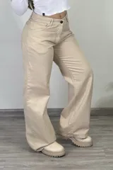 Pantalón de jean color beige, estilo baggy o wide leg, de tiro medio, con cierre de botón y cremallera.