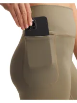 Calza deportiva de tiro alto con bolsillos laterales, confeccionada en tejido de punto elástico y suave con tecnología de absorción de sudor.