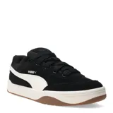 Championes urbanos Puma modelo Park Life Style SK8, color negro con detalles en blanco. Presentan un diseño de corte bajo con capellada de gamuza sintética, suela de goma en tono crema con base marrón y cierre mediante cordones.