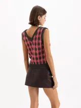Chaleco de punto jacquard sin mangas, con escote en V y diseño a cuadros en tonos gris y rosado.