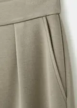 Pantalón verde militar de corte recto y tiro alto, con bolsillos laterales y pinzas frontales.