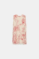 Top sin mangas confeccionado en hilatura de viscosa, con cuello redondo y cierre en la espalda con abertura y botón. Presenta un diseño con estampado paisley a contraste en color rojo sobre fondo beige.