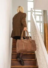 Bolso de mano tipo shopper marca Amadea, confeccionado en cuero con acabado desgastado. Presenta detalles de costuras decorativas verticales, correas con hebillas metálicas doradas y logo grabado al frente.