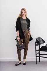 Pantalón babucha de tiro medio, ajustado en tobillos, con estampado de piel de serpiente en tonos marrones y negros. Posee bolsillos diagonales y cintura elastizada con cordón de ajuste.