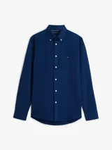 Camisa de corte slim color azul con textura dobby, manga larga, cuello abotonado y cierre frontal con botones blancos. Presenta el logo bordado de Tommy Hilfiger en el pecho.