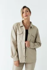 Sobrecamisa color beige de efecto cuero, con cuello clásico, cierre frontal con botones a tono, mangas largas con puños abotonados, dos bolsillos con solapa en el pecho y corte recto.