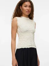 Top tejido color crema, sin mangas y con cuello redondo. Confeccionado en punto plano con mezcla de viscosa LENZING™ ECOVERO™ y nailon. Diseño de calce regular, textura suave y caída ligera.