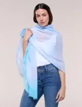 Pashmina tejida Barrington con diseño degradé en tonos celestes y blancos, terminación desflecada.