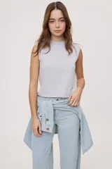 Remera sin mangas negra con cuello redondo y hombros estructurados con hombreras, de corte recto y largo a la cintura.
