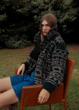 Saco de lana tejido con diseño jacquard en tonos topo, verde y rosado. Presenta cuello chal y botones frontales.