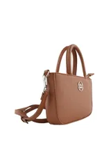 Cartera tipo bandolera de diseño compacto, color rosado, con doble asa superior y correa ajustable extraíble. Presenta un aplique metálico circular con logo en el centro y cierre superior.