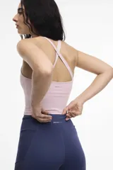Top deportivo color crema, con espalda baja y copas removibles.