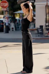 Jeans de mezclilla en color negro con efecto lavado, de tiro alto y cinco bolsillos, con perneras extra anchas y cierre frontal con cremallera y botón metálico.