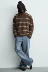 Jersey de punto con textura, corte relajado, cuello redondo y manga larga. Presenta un diseño de rayas horizontales en tonos marrones y grises con acabados en rib.