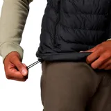 Chaleco acolchado negro con cierre frontal, cuello alto y bolsillos laterales con cierre. Presenta tecnología térmica reflectante y aislamiento sintético, diseñado para actividades al aire libre.
